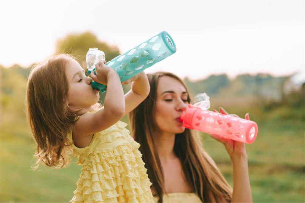 Frau und Kind beim Wasser trinken